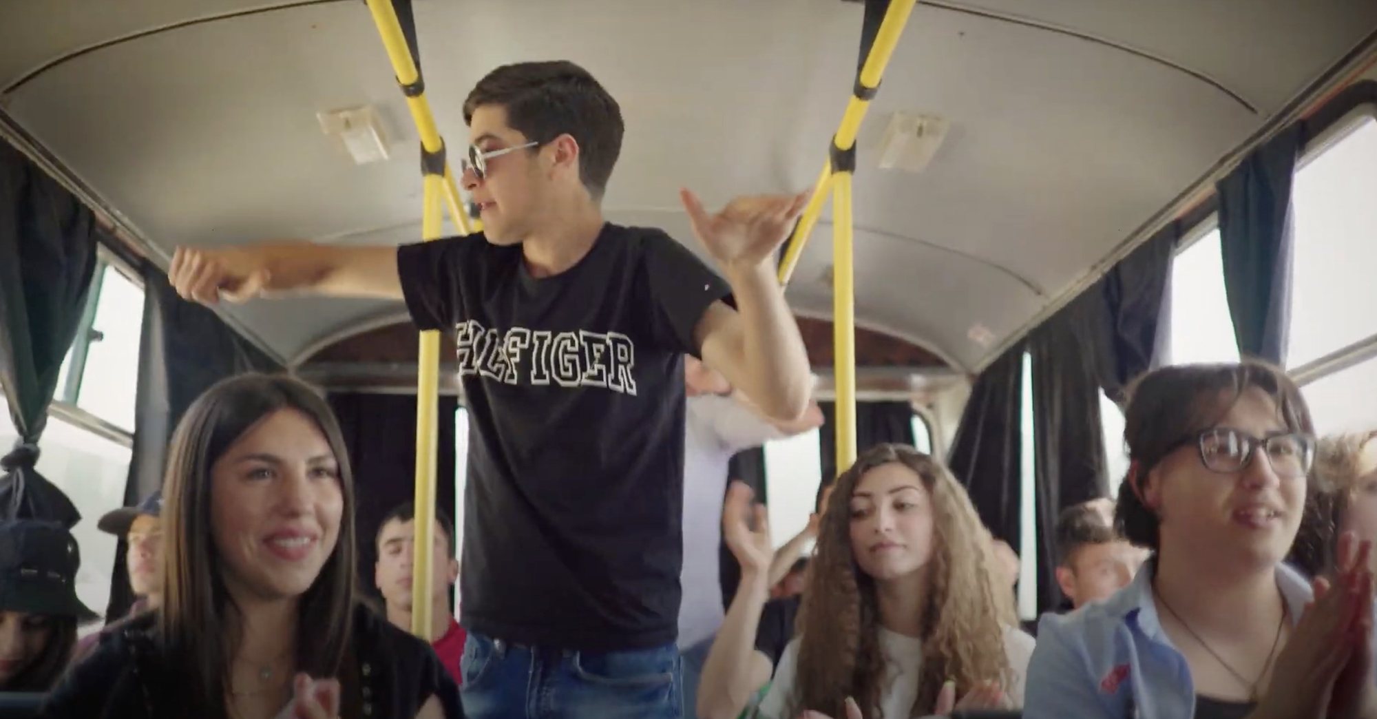 Teenagers laugh and talk together on a bus