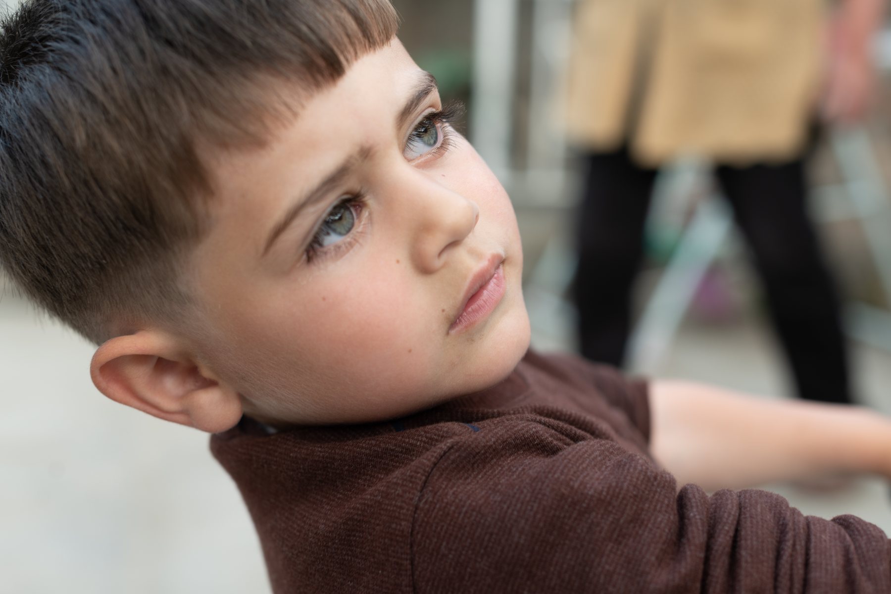 A small boy looks up past the camera