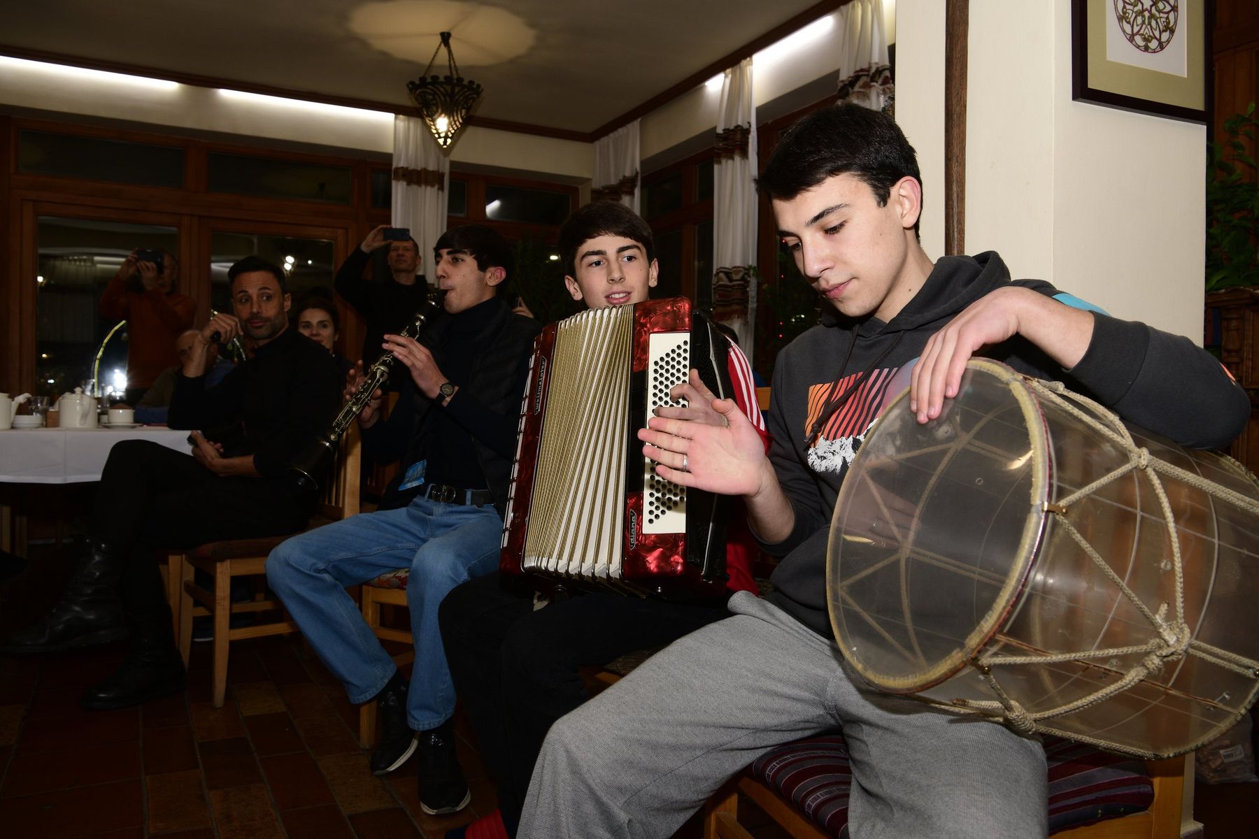 Boys play accordion, clarinet and drum in the hotel dining room