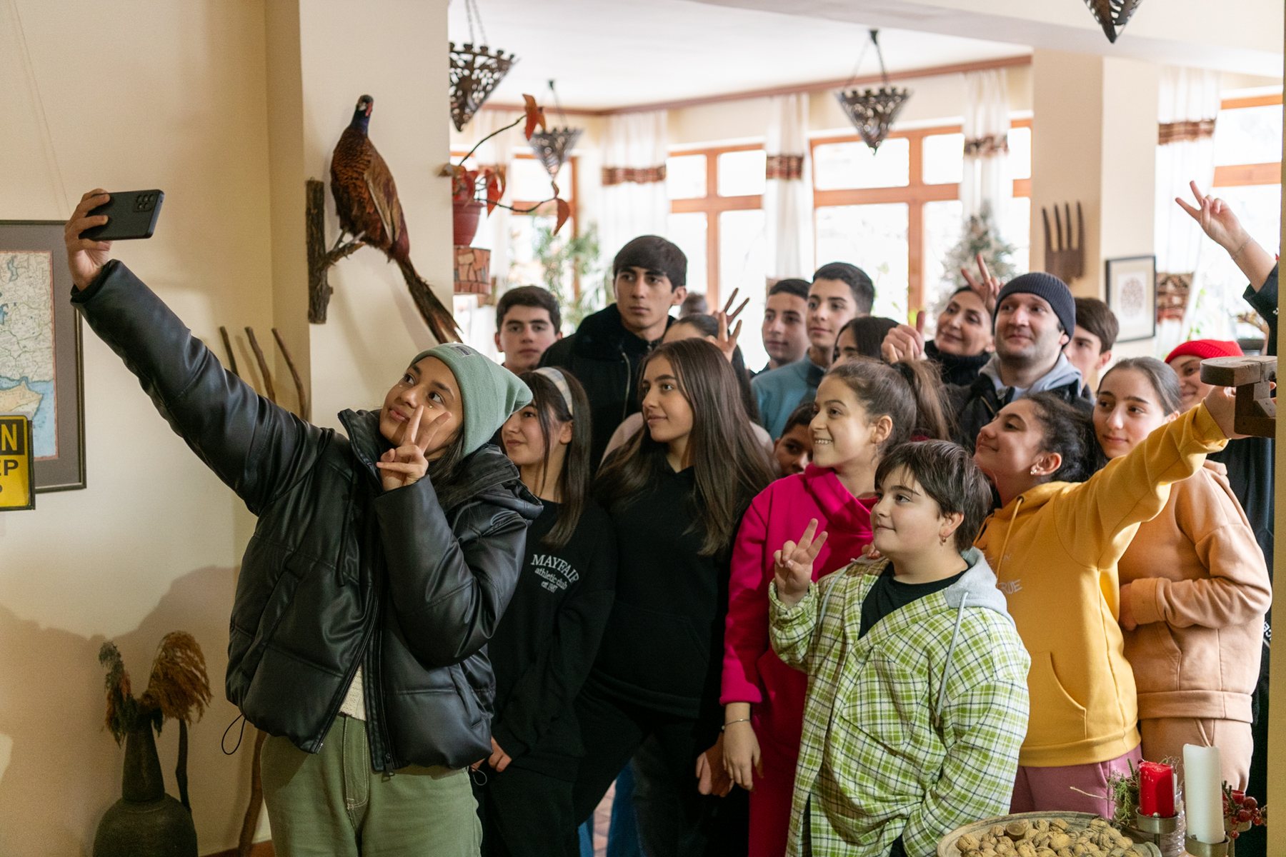 A crowd of children waves in the hotel lobby