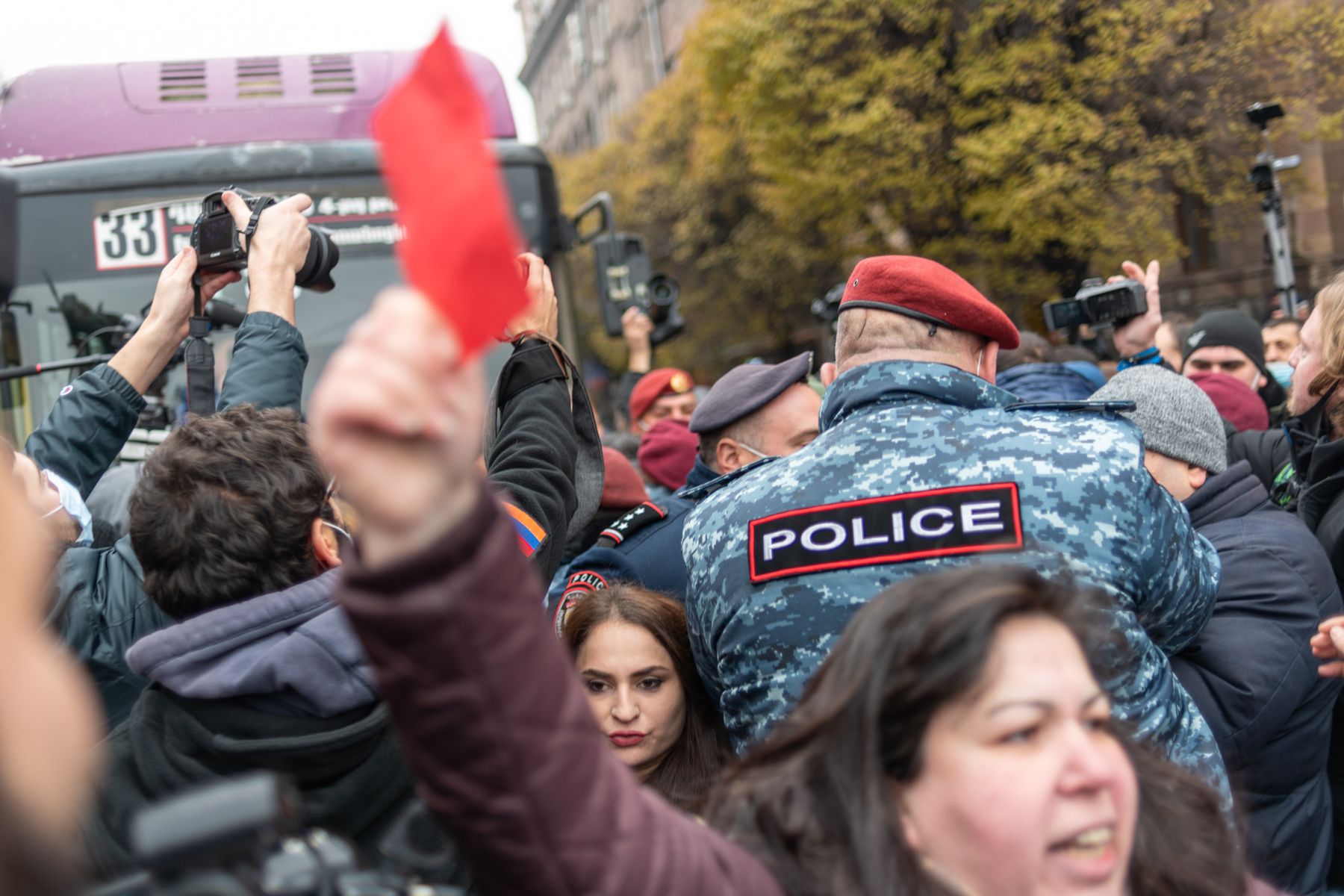 A woman holds up a red card in front of police officers