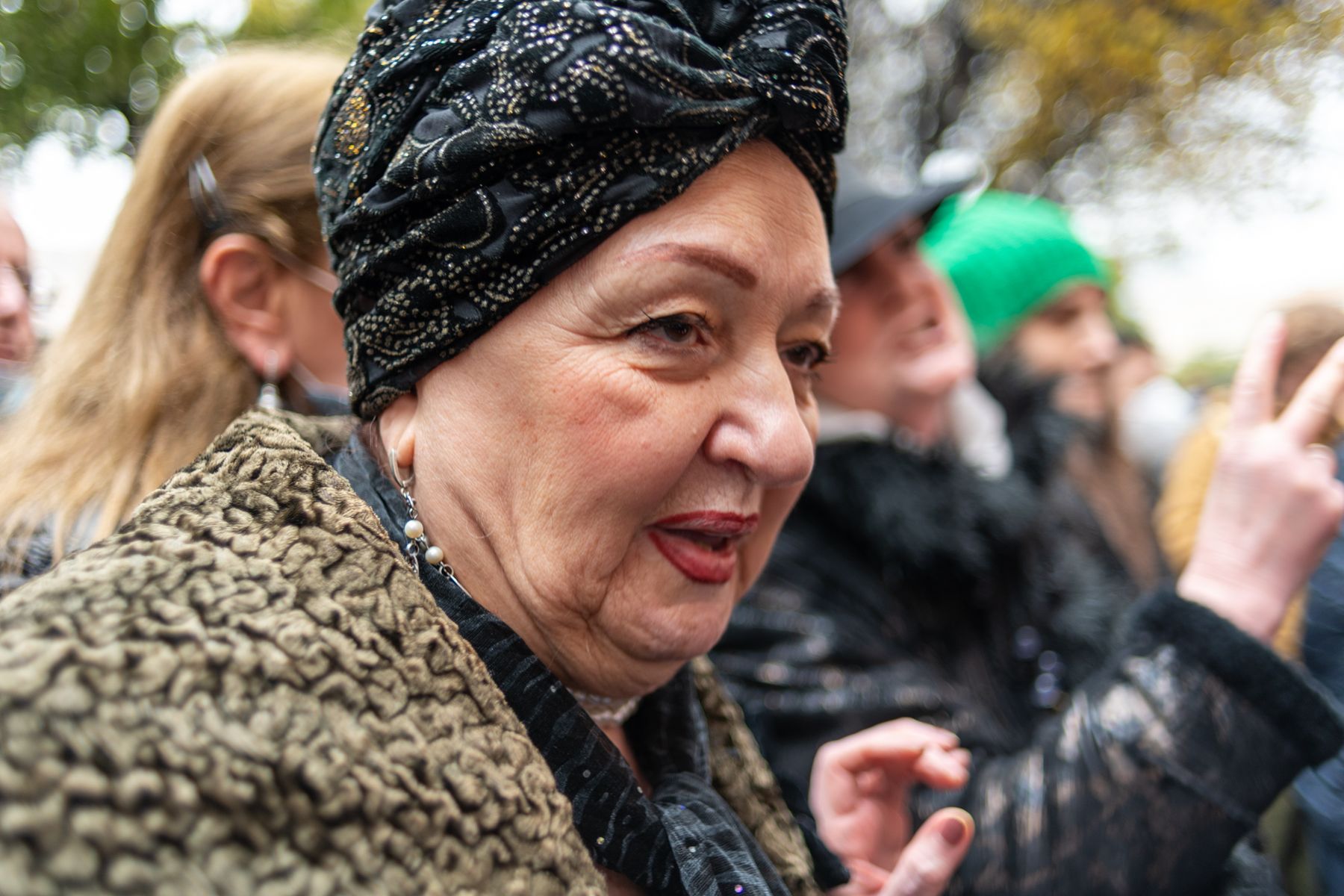 A woman in a dark turban speaks out in the crowd