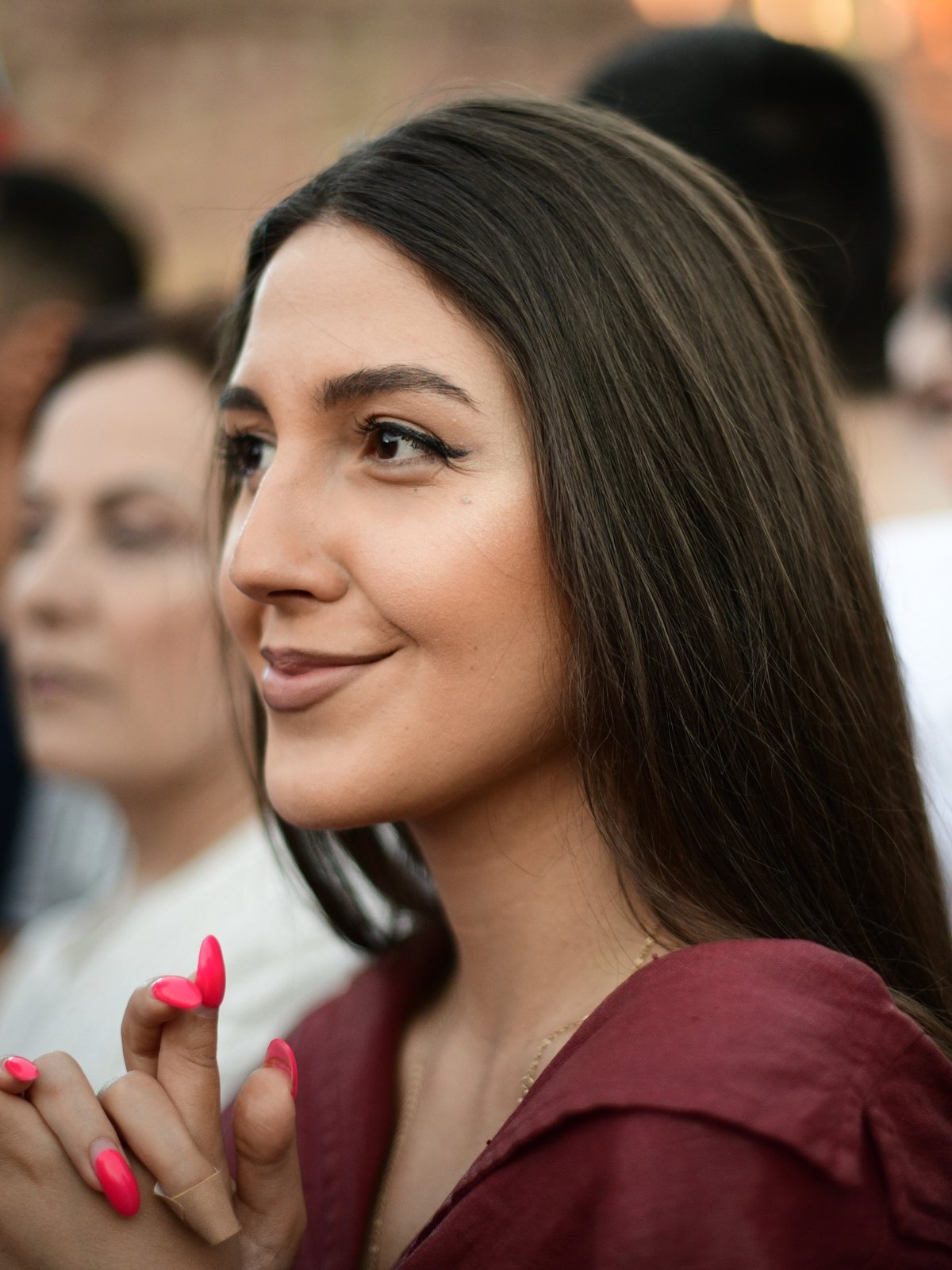 A young woman in red smiles to one side, Yerevan