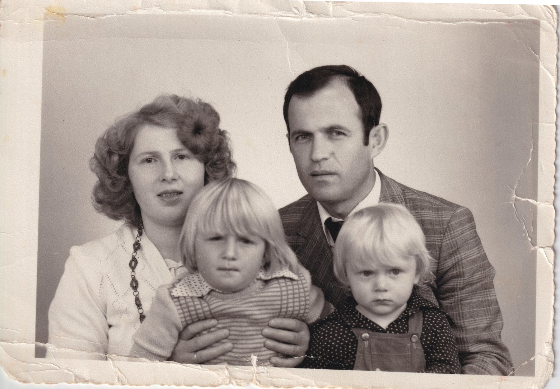 A studio portrait of a mother, father and two small fair-haired children