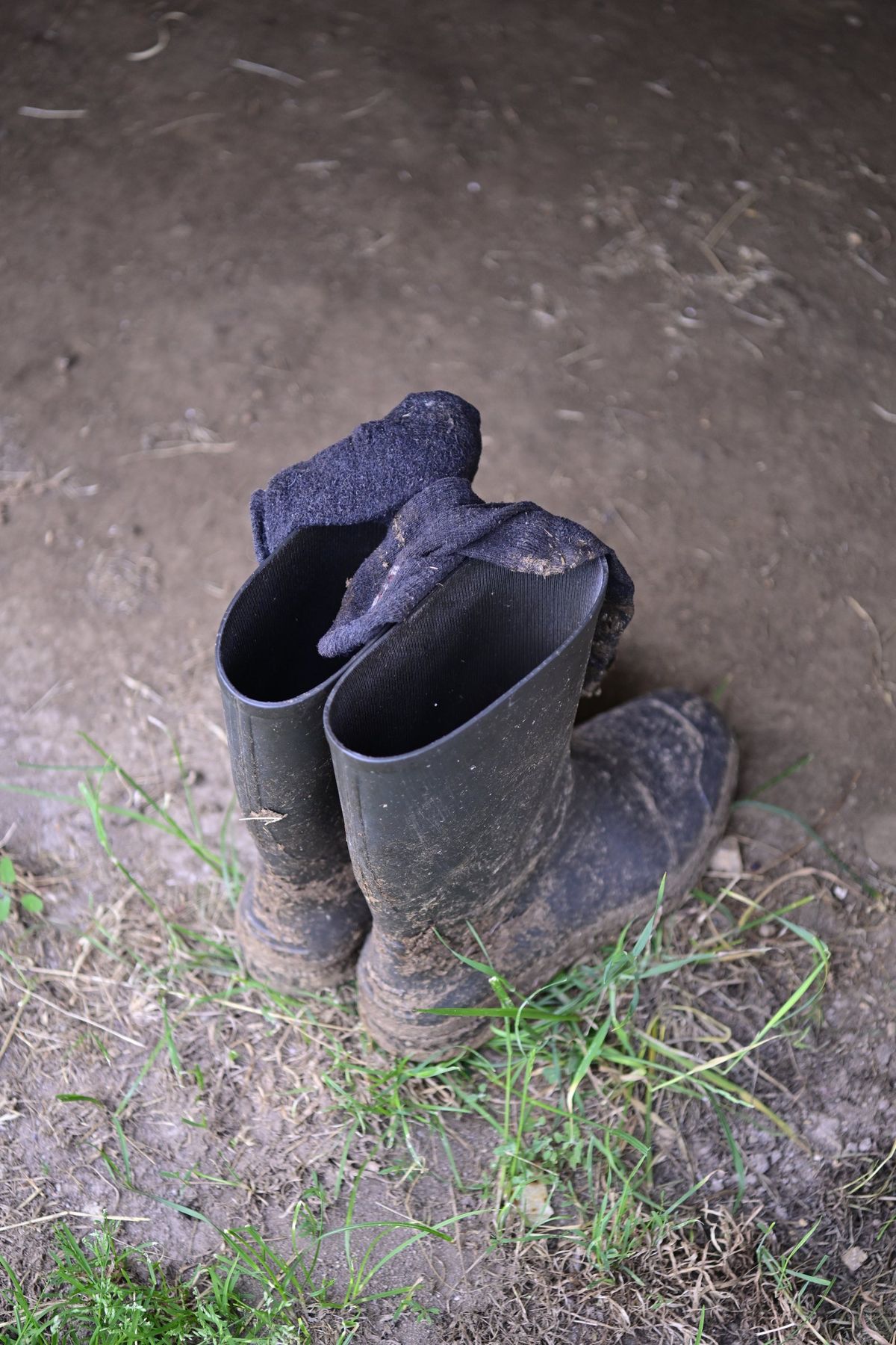 A pair of rubber boots left upside down in the grass