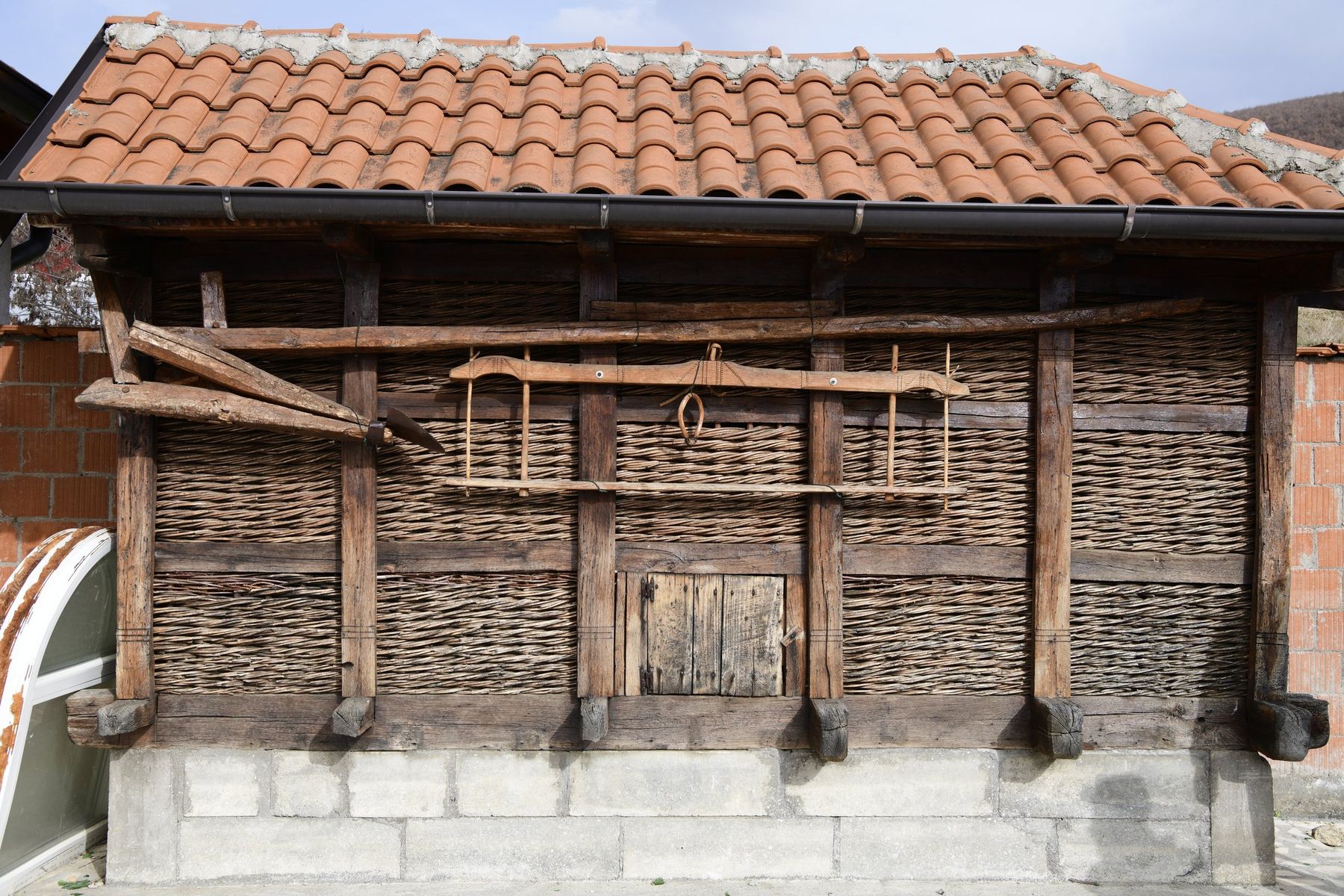 An old granary of woven branches under a tiled roof