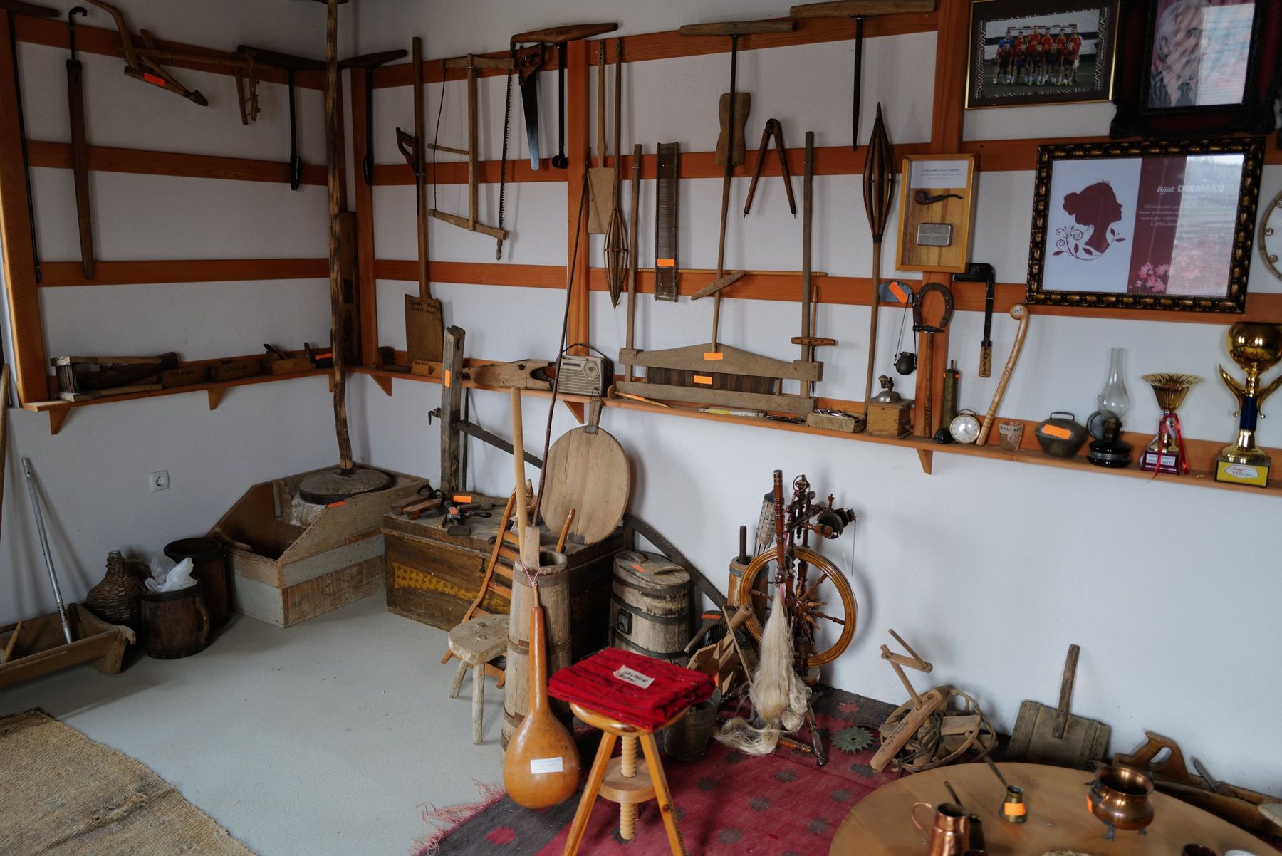 A small village museum room with tools, instruments and photographs on the walls