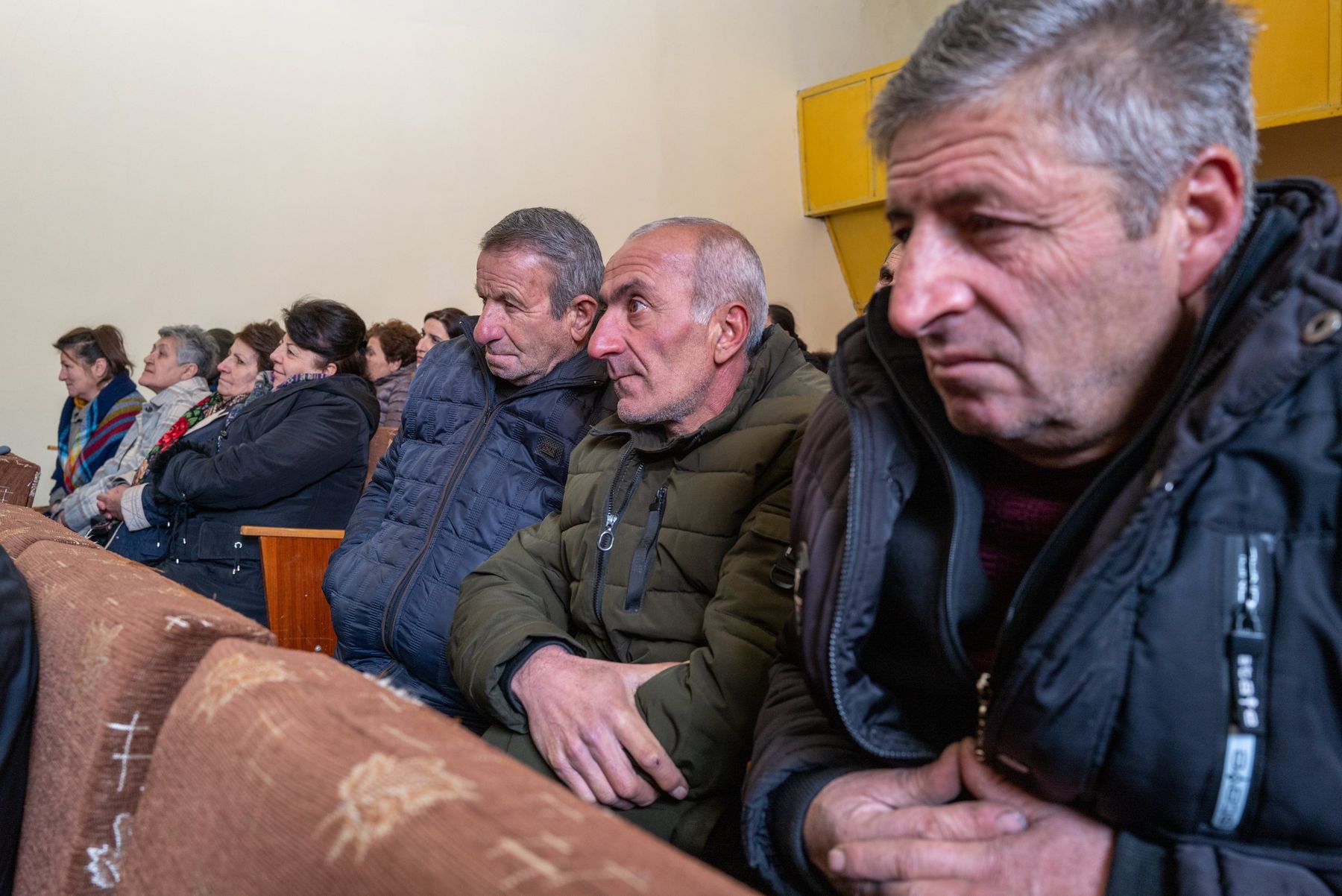 Men from the village watch the screening intently