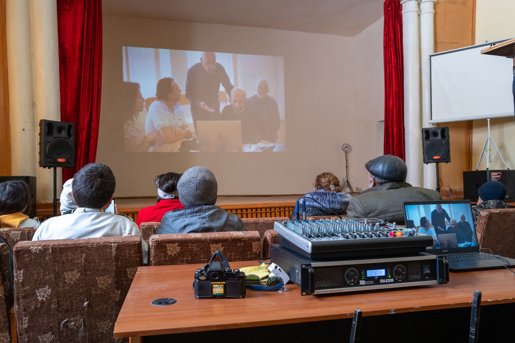 Villagers watch the film projected in the community hall