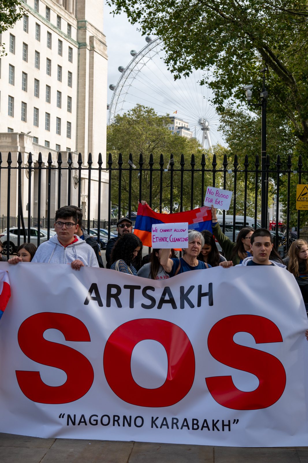 A large Artsakh SOS banner held up in front of the crowd