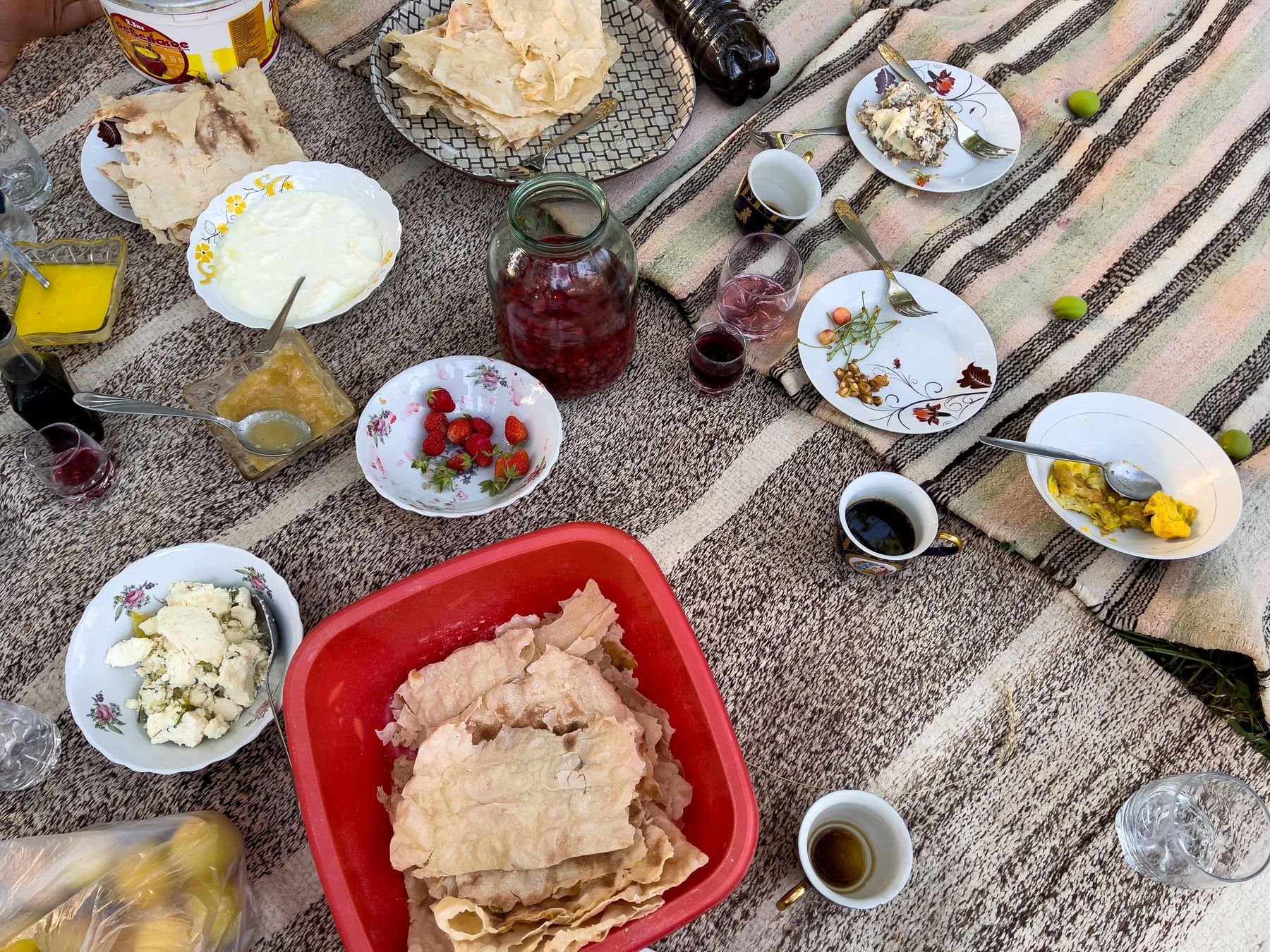 A table spread with bread, cheese, jam and coffee, seen from above