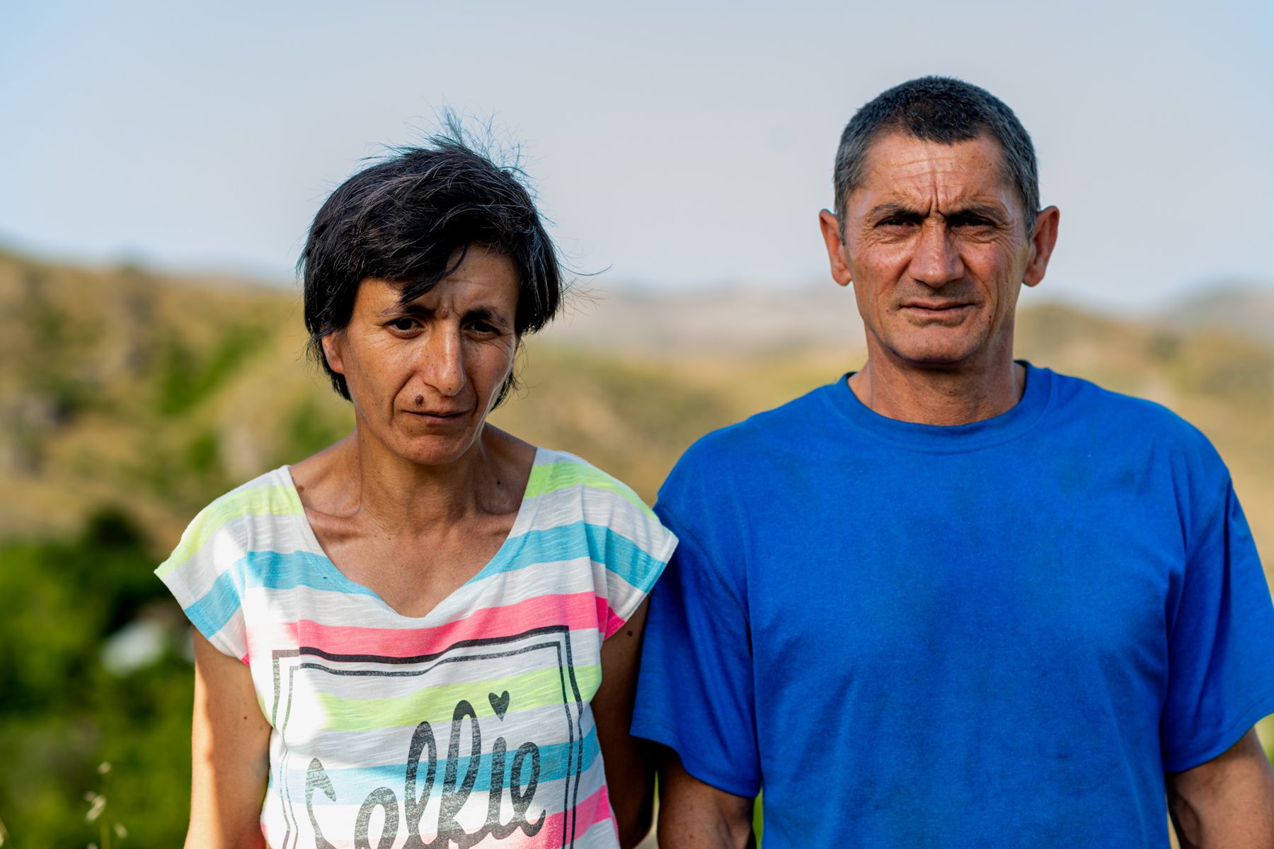 A woman and a man in a blue T-shirt, close together