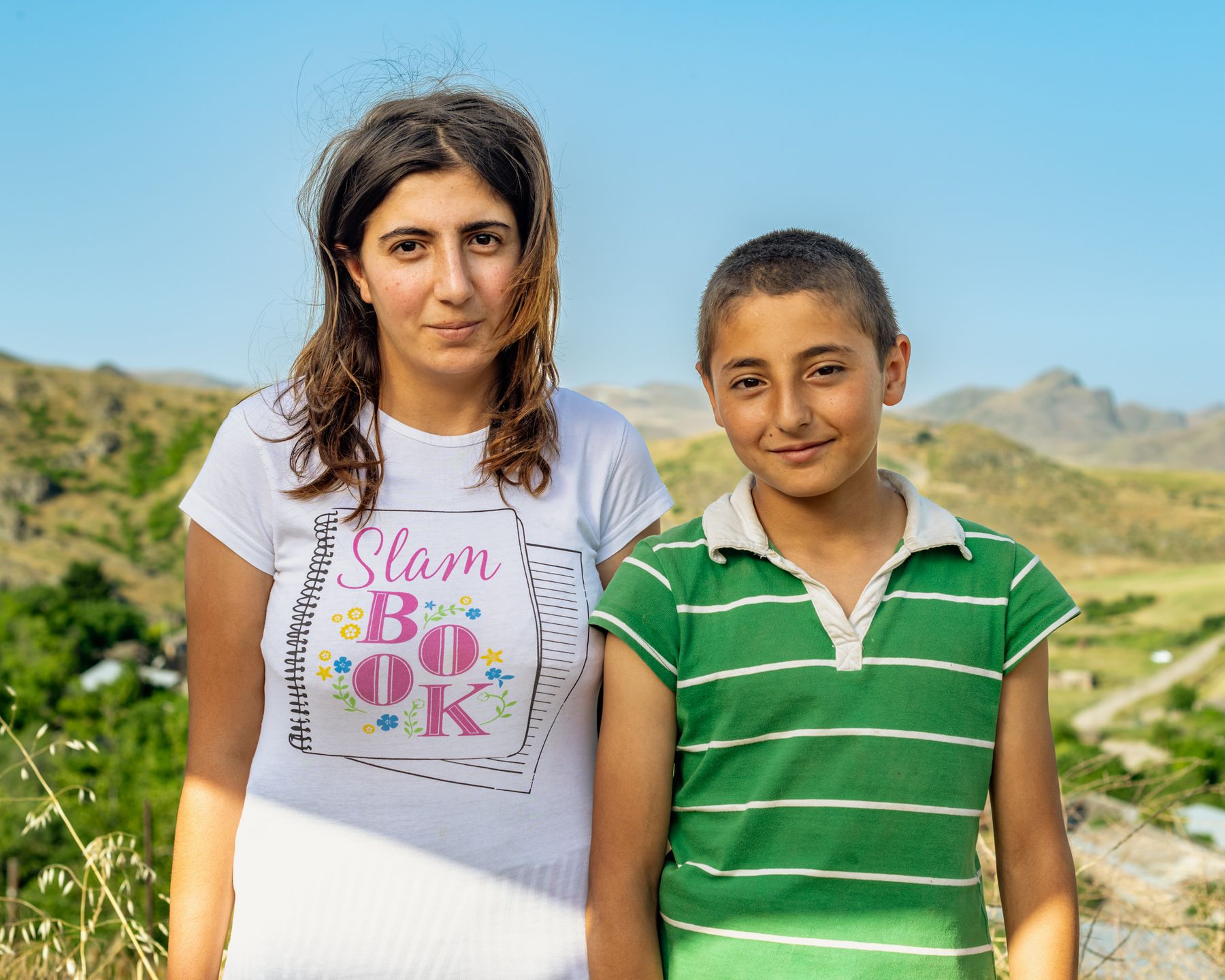 A young woman and a boy in a green striped shirt
